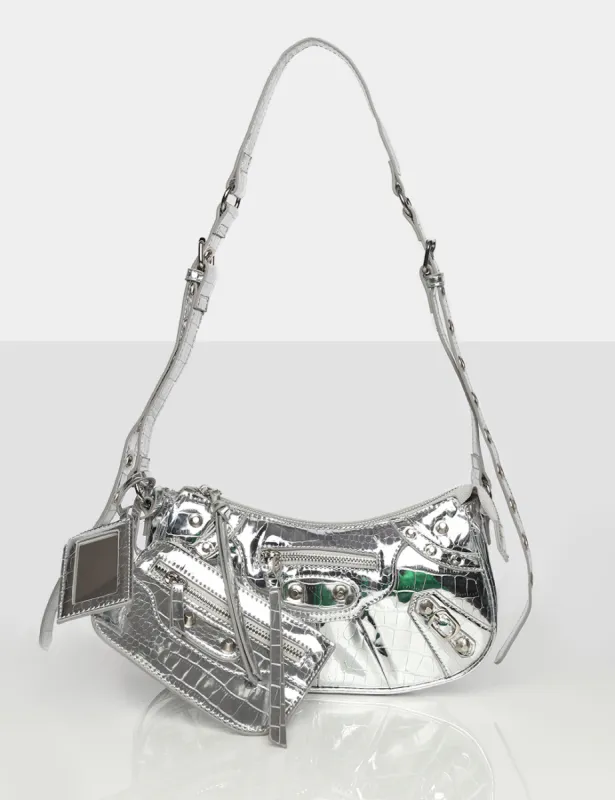 The Trackstar Metallic Silver Croc Studded Mirror Zip Detail Handbag sold by Public Desire