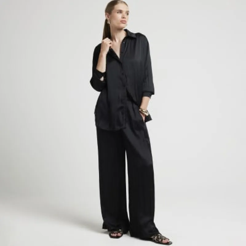 Black satin crinkle trousers sold by River Island