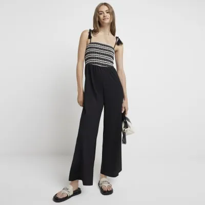 Black crochet tie strap jumpsuit sold by River Island