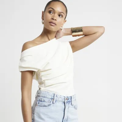 Cream off shoulder drape top sold by River Island