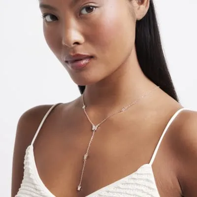 Rose gold colour butterfly necklace sold by River Island