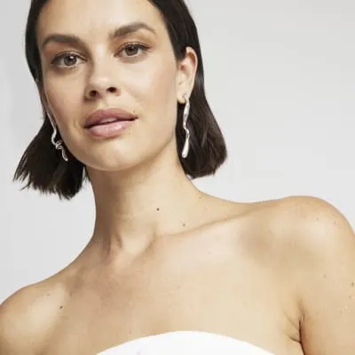 Silver twisted drop earrings sold by River Island