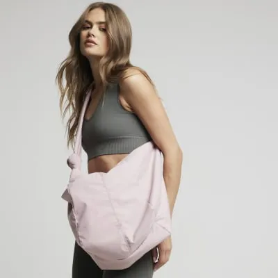 Pink knot scoop cross body bag sold by River Island