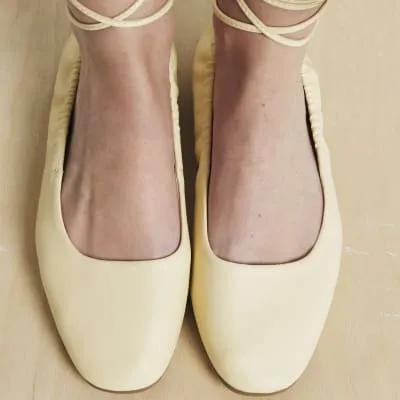 Yellow tie up ballet pumps sold by River Island