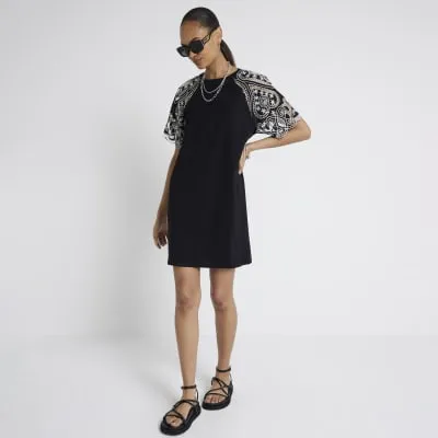 Black broderie sleeve mini t-shirt dress sold by River Island