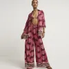 Pink palm tree wide leg beach trousers sold by River Island