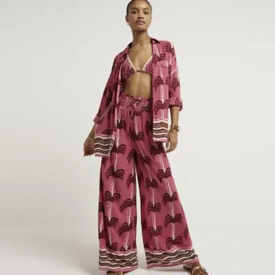 Pink palm tree wide leg beach trousers sold by River Island