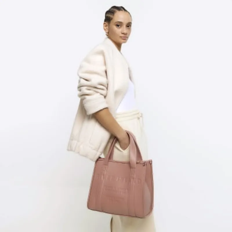 Pink embossed cross body tote bag sold by River Island
