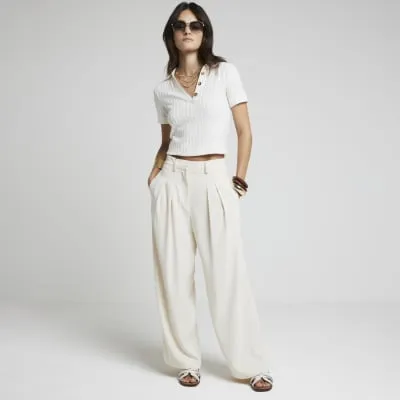 Cream wide leg trousers sold by River Island