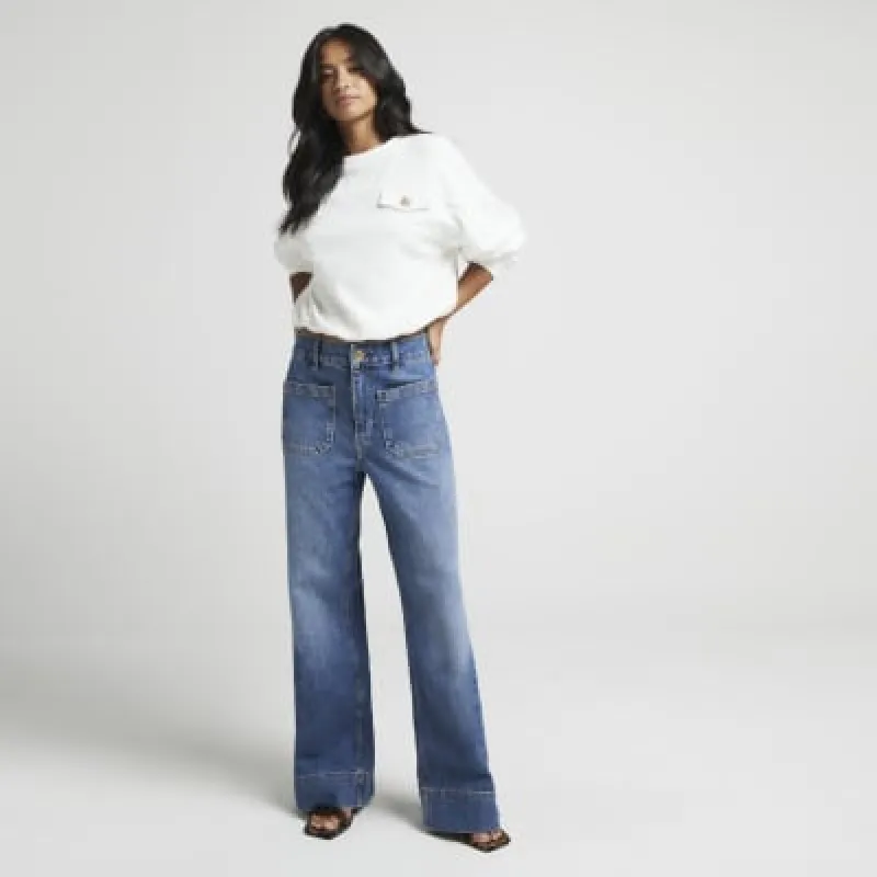 Petite blue high waisted wide flared jeans sold by River Island