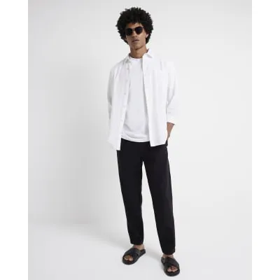 Black tapered fit pull on trousers sold by River Island