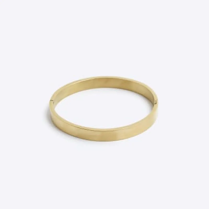 Gold colour stainless steel bangle bracelet sold by River Island
