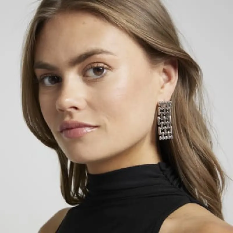 Silver watch strap drop earrings sold by River Island