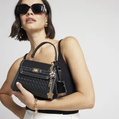 Black embossed mini top handle cross body bag sold by River Island