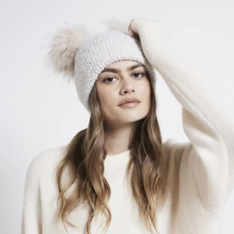 Cream sequin double pom pom beanie sold by River Island