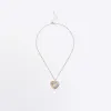 Gold heart necklace sold by River Island