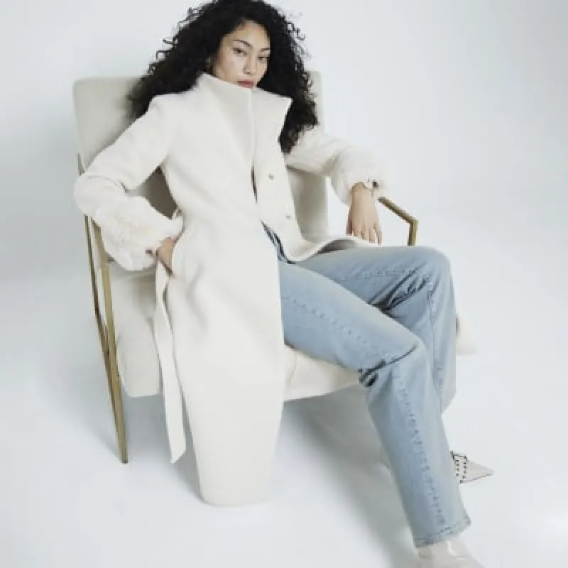Cream faux fur cuff longline coat sold by River Island