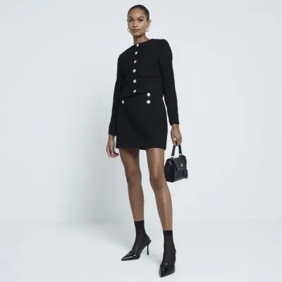 Black boucle button detail mini skirt sold by River Island