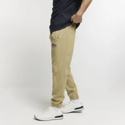 Green regular fit graphic cuffed joggers sold by River Island