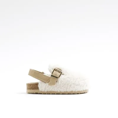 Mini girls cream borg buckle clogs sold by River Island