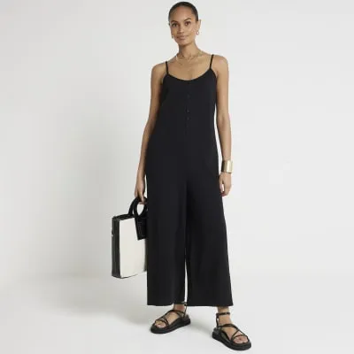 Black textured button jumpsuit sold by River Island