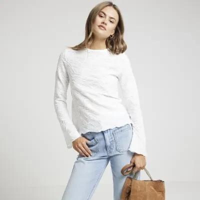 Cream lace long sleeve top sold by River Island