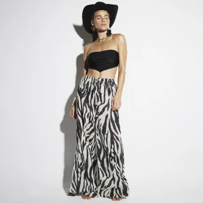 Black zebra print wide leg beach trousers sold by River Island