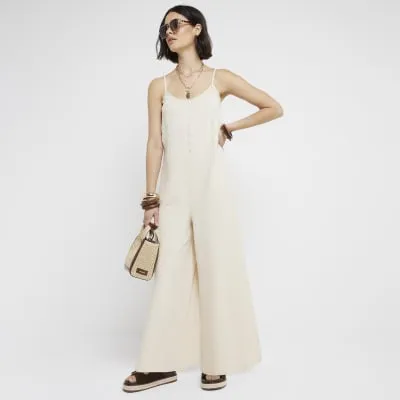 Cream textured button jumpsuit sold by River Island