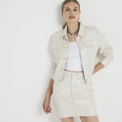 Beige metallic coated denim mini skirt sold by River Island