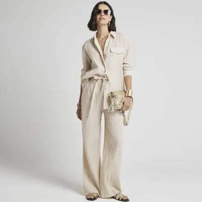 Beige textured wide leg trousers sold by River Island