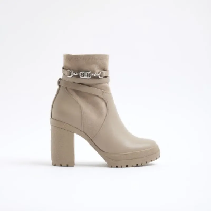 Beige wide fit hardware strap heeled boots sold by River Island