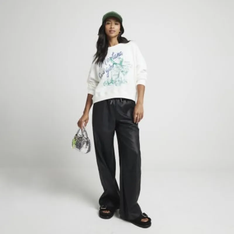 Petite black faux leather wide leg trousers sold by River Island