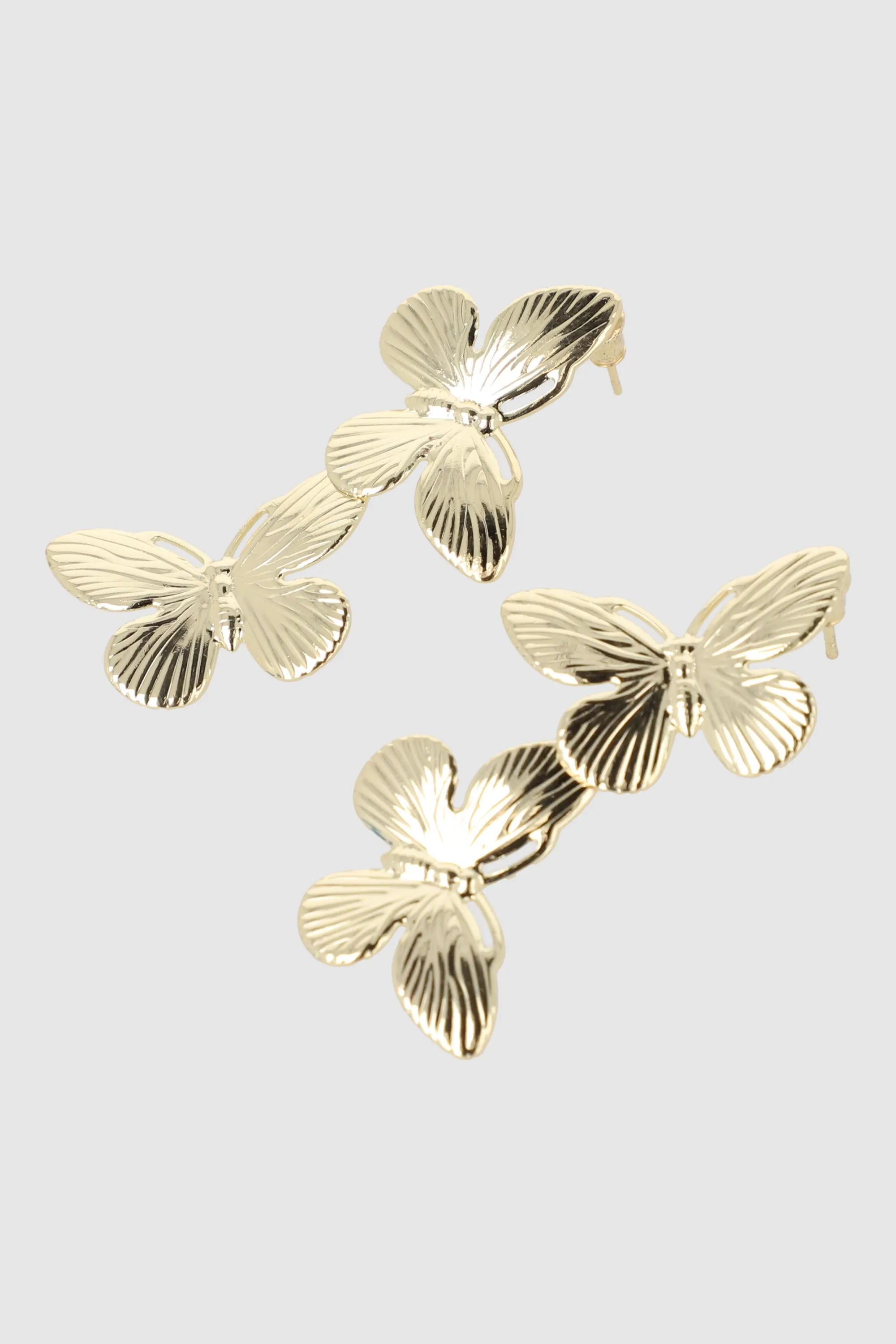 Aretes doble mariposas sold by Shasa