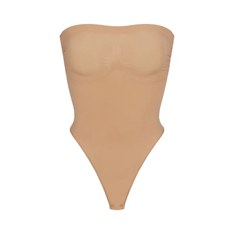 SEAMLESS SCULPT STRAPLESS THONG BODYSUIT | OCHRE sold by SKIMS