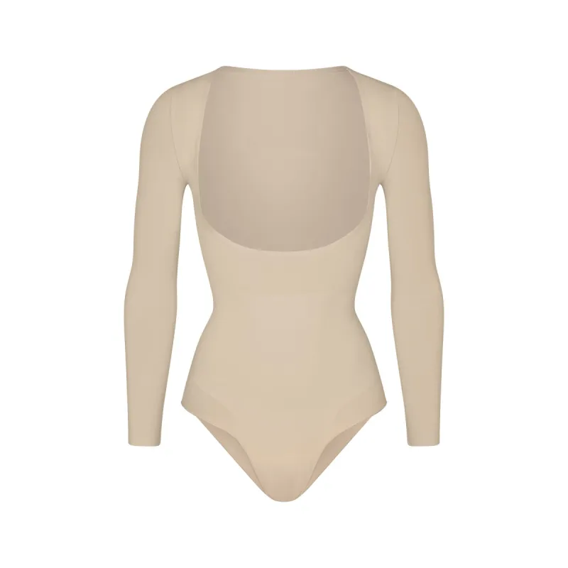 SEAMLESS SCULPT LONG SLEEVE OPEN BUST BRIEF BODYSUIT | SAND sold by SKIMS