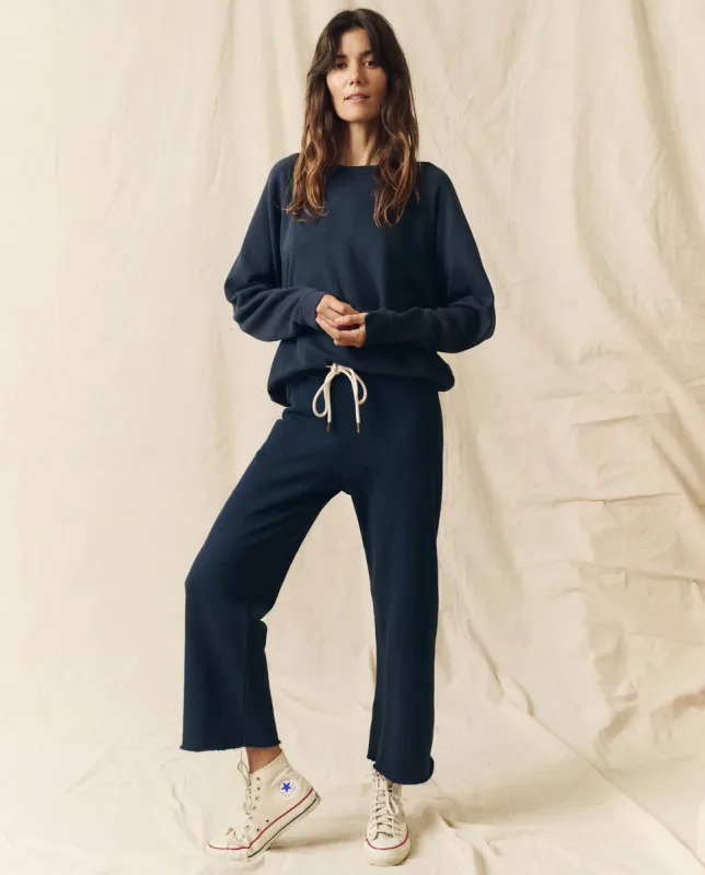 The Wide Leg Cropped Sweatpant. -- True Navy sold by THE GREAT.