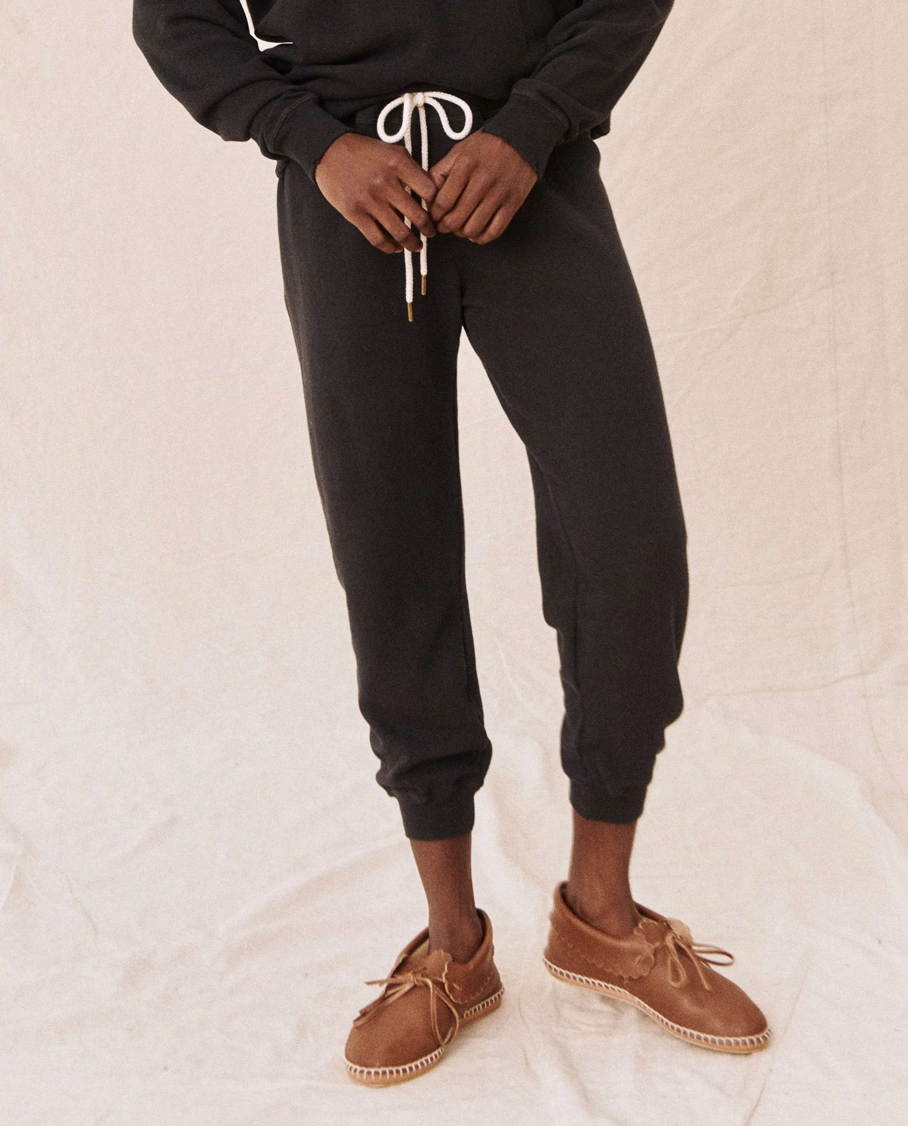 The Cropped Sweatpant. Solid -- Almost Black sold by THE GREAT.