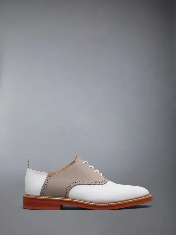 NUBUCK RUBBER SOLE SADDLE SHOE sold by Thom Browne