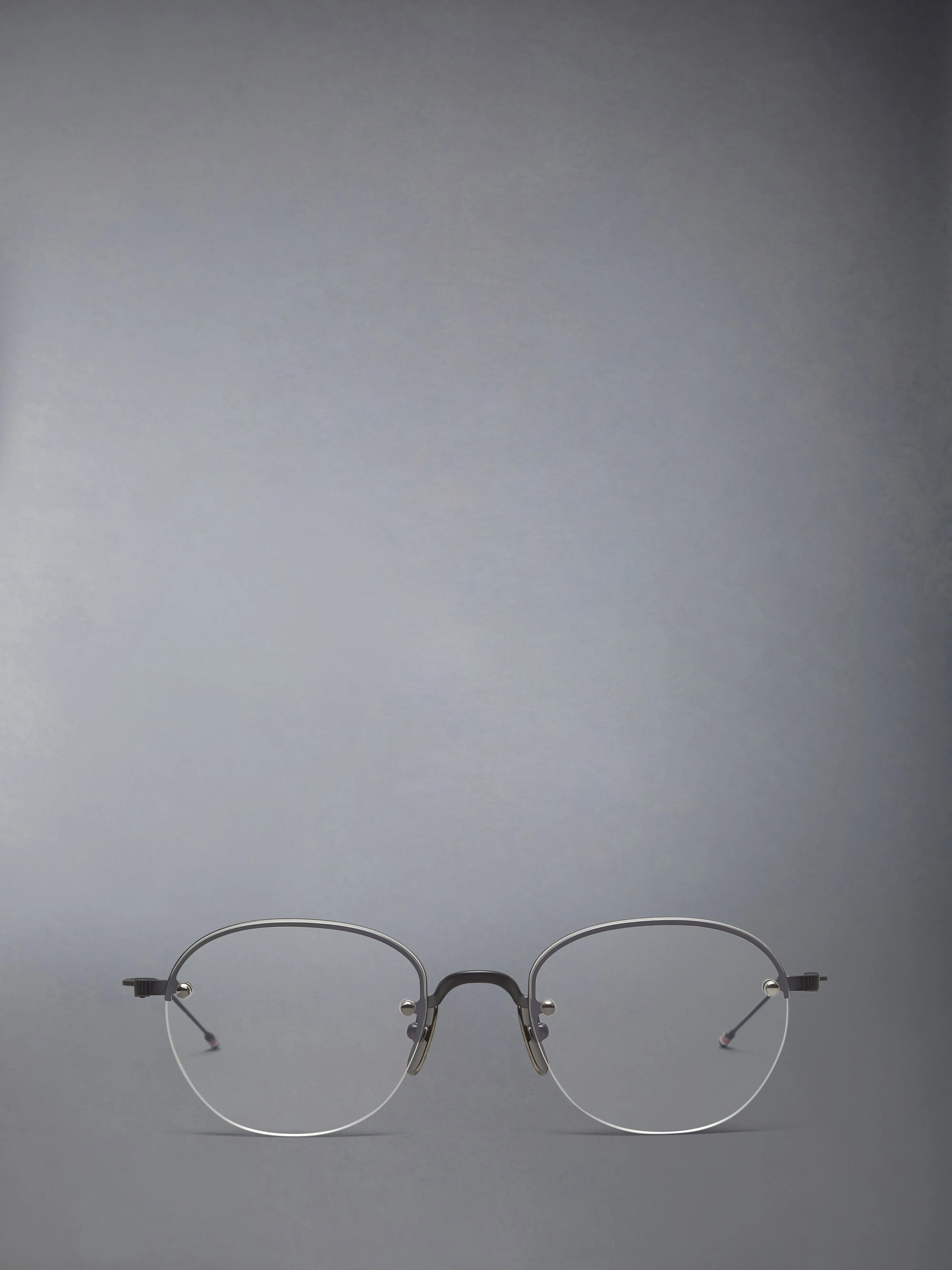 TITANIUM SEMI RIMLESS OVAL EYEGLASSES sold by Thom Browne