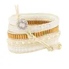 Crystals with Long Gold Beads on White sold by Victoria Emerson