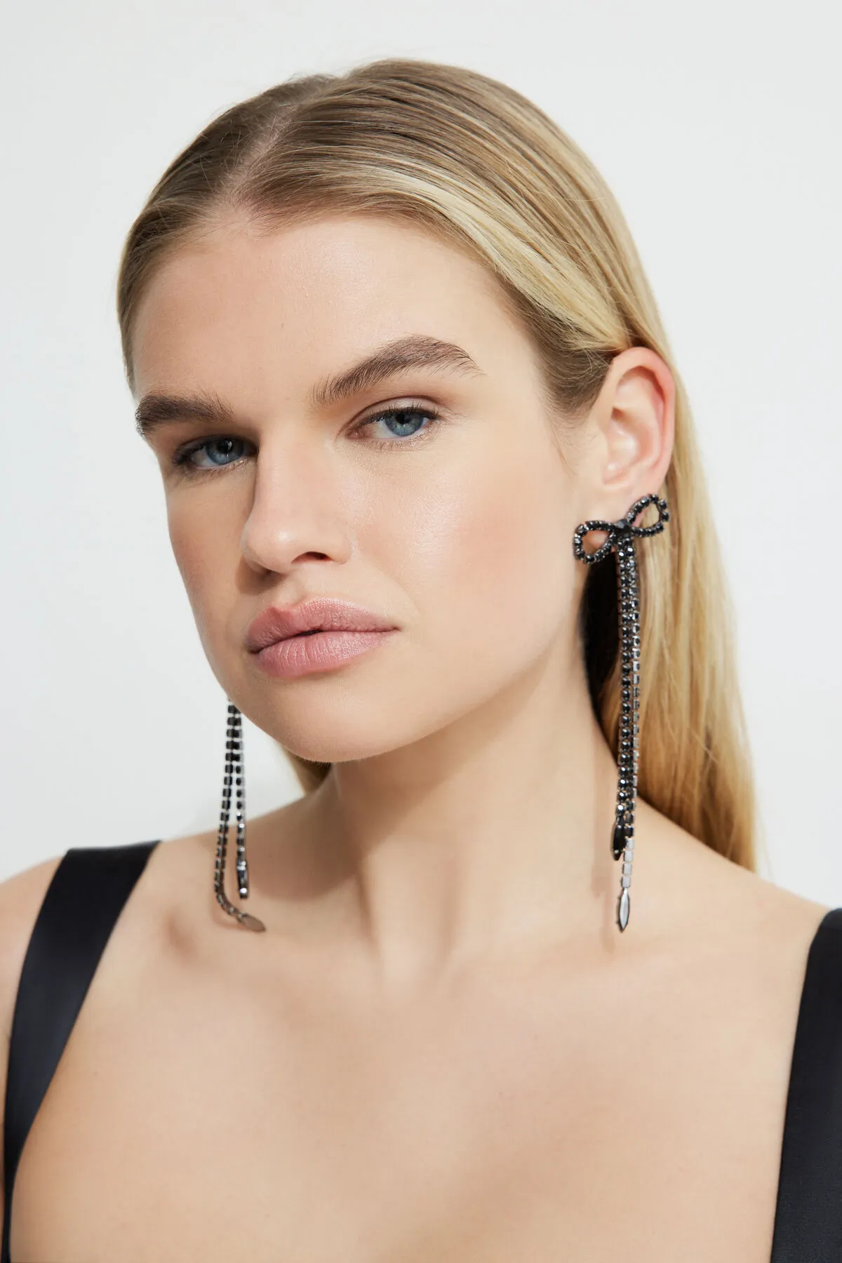 Oversized Hanging Gem Bow Earrings sold by Dynamite