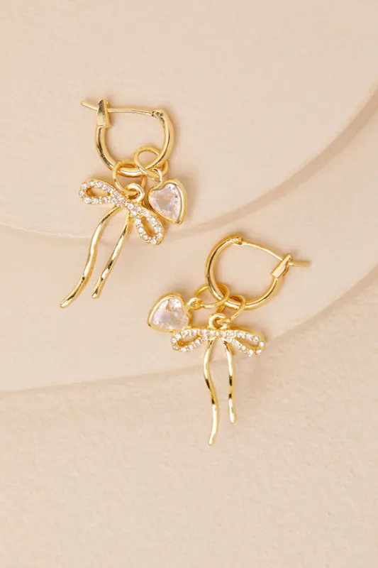 Wrenley 14KT Gold Bow Rhinestone Charm Huggie Hoop Earrings sold by Lulus