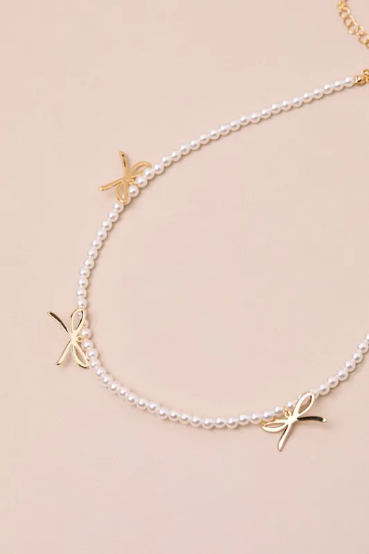 Arquette White Pearl Bow Charm Necklace sold by Lulus