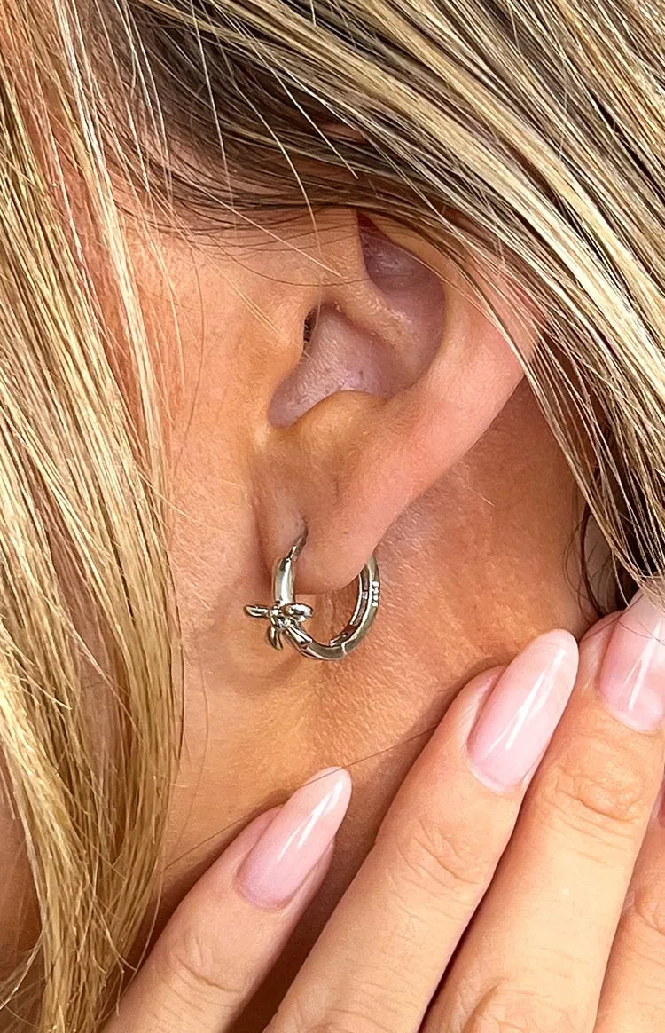 Darling Silver Bow Huggie Earrings sold by Beginning Boutique