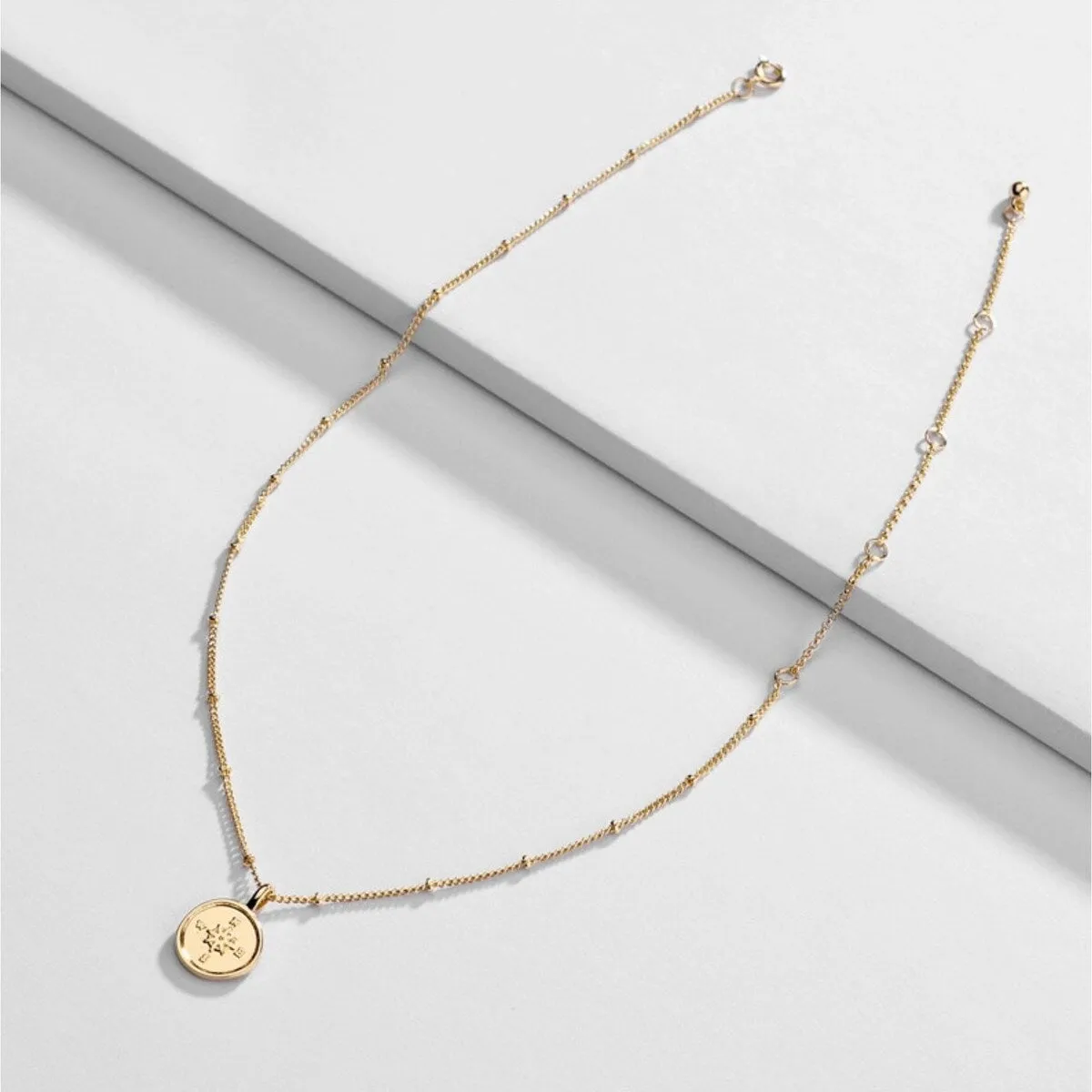 Goldtone Dainty Compass Pendant Necklace - White sold by Zulily