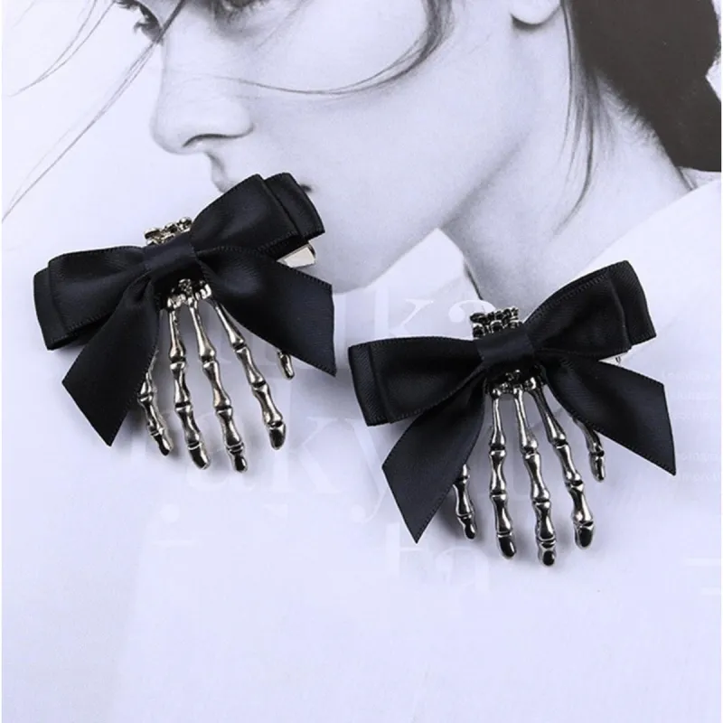 Black Bow & Silver Skeleton Hand Earrings sold by Zulily