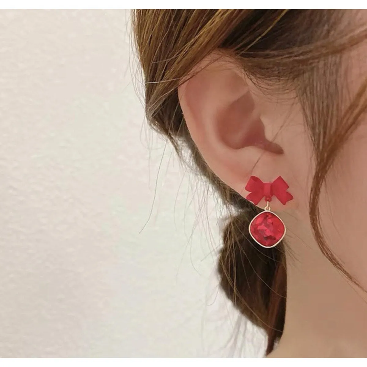 Red Crystal Bow Drop Earrings In Gold sold by Zulily