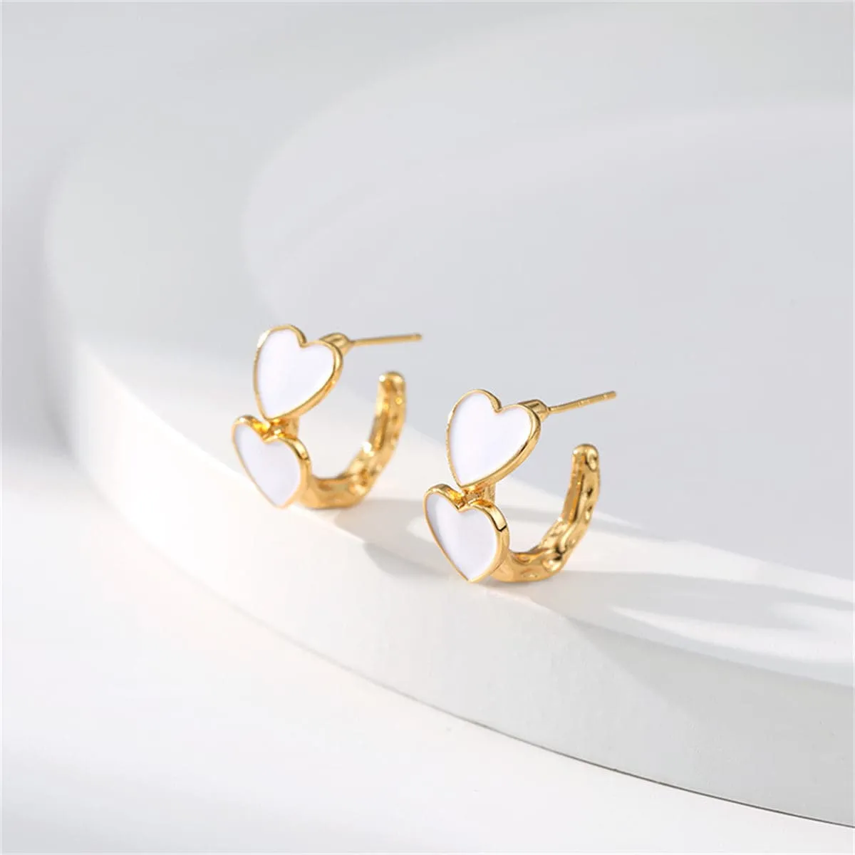 White Enamel & Goldtone Heart Huggie Earrings sold by Zulily