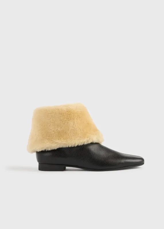 Downtown shearling boots black/beige sold by Toteme
