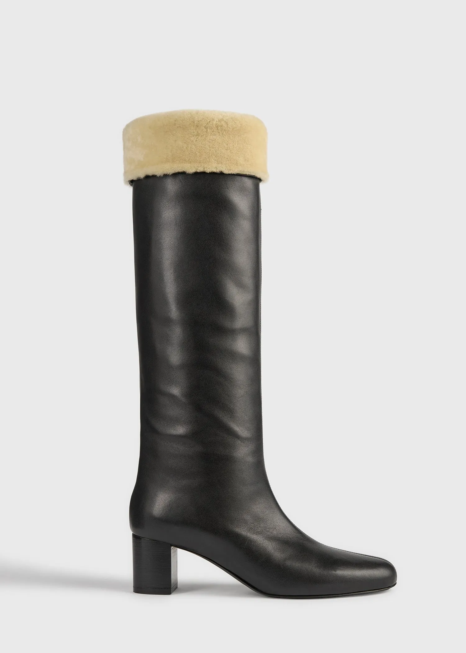 Downtown shearling knee-high boots black/beige sold by Toteme